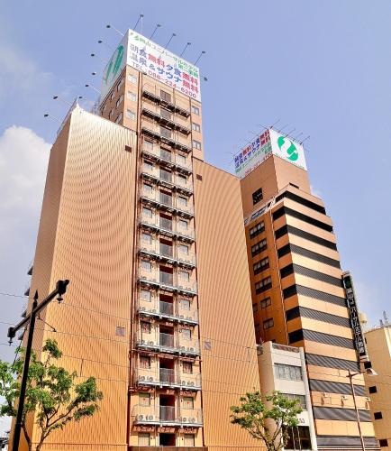 two tall buildings in a city with birds in the sky at Okayama Universal Hotel Annex 2 in Okayama