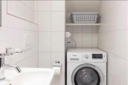 a bathroom with a washing machine and a sink at Zurich 2 Bedrooms Apartment in Zürich