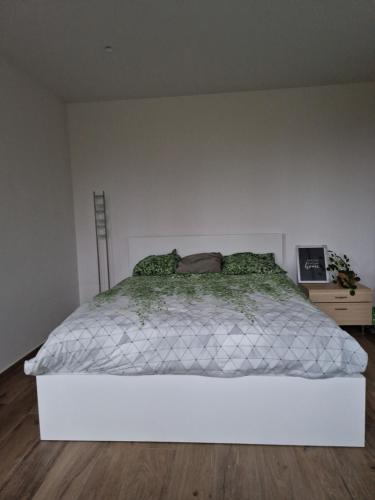 ein weißes Bett in einem Zimmer mit einer weißen Wand in der Unterkunft Hele gezinswoning met zwembad te huur in Mechelen