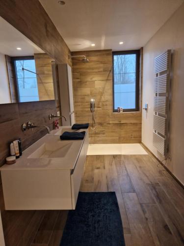 een badkamer met een grote wastafel en een douche bij Hele gezinswoning met zwembad te huur in Mechelen