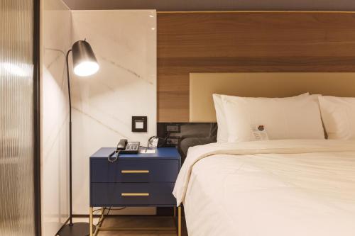 a bedroom with a bed and a blue night stand at 墾丁耳東華苑ErDong Manor in Kenting