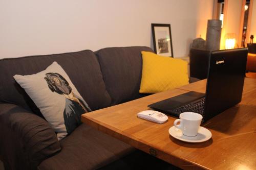 a coffee table with a laptop on a couch at Clos De La Vaupalière - Rouen in La Vaupalière