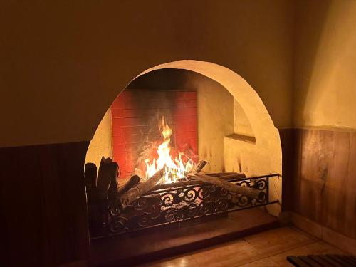 a brick fireplace with a fire in it at Kanjira house in Ooty