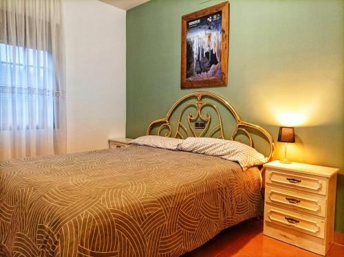 a bedroom with a bed and a dresser and a picture at Hostal Restaurante Solaire in Castañar de Ibor