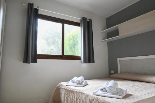 1 dormitorio con 1 cama con toallas en Giardino Don Berardino, en Mattinata