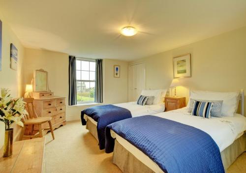 a bedroom with two beds and a window at The Mount in Padstow