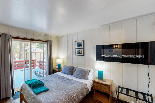 1 dormitorio con 1 cama, TV y balcón en Tahoe Twilight, en Carnelian Bay
