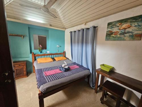 a bedroom with a bed with a table and a piano at La Bamba in Willemstad