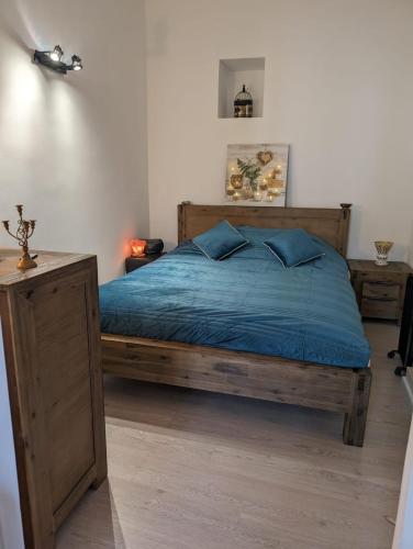- une chambre avec un lit en bois et des draps bleus dans l'établissement 2 pièces , Centre ville , 100 mètres des plages., à Menton