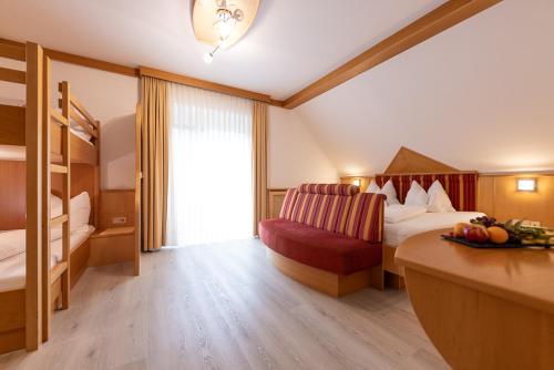 a hotel room with a bed and a red chair at Maria Theresien Hof Loipersdorf in Jennersdorf