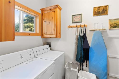 lavadero con lavadora y secadora y ventana en Cascade Woods, en Tahoma