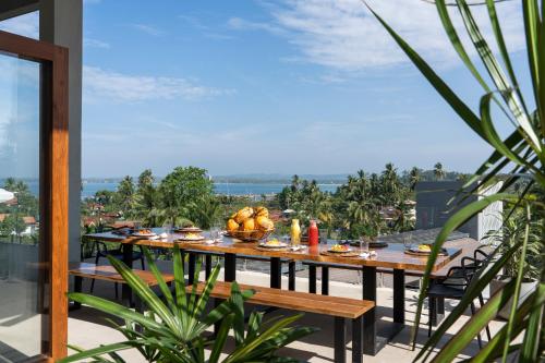 a table with food on top of a balcony at The Nine Mirissa in Mirissa