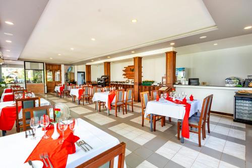 um restaurante com mesas e cadeiras com arcos vermelhos em Green Amazon Residence Hotel em Siem Reap
