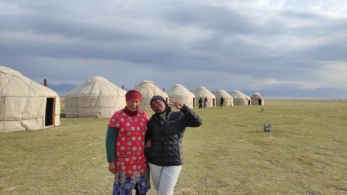 two people standing in front of a group of tents at Yurt Camp Ali-Nur, Lake Song-Kul , Kyrgyzstan, Юрточный лагерь Али Нур, на берегу озера Сон Кол in Naryn