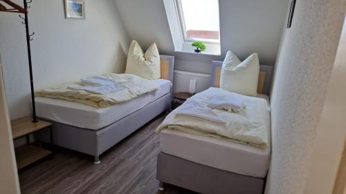 two beds in a small room with a window at Schillerstrasse in Burgstaedt