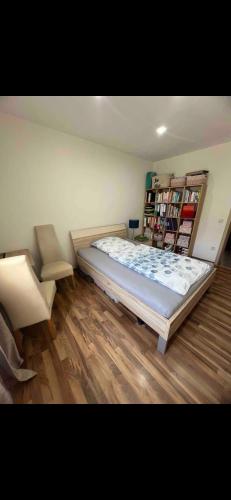 1 dormitorio con 1 cama grande y estante para libros en Privatzimmer , mit sehr guter Verkehrsanbindung en Núremberg