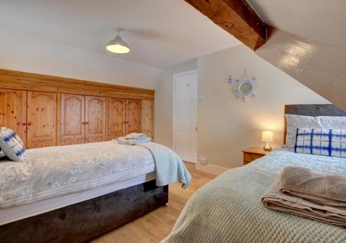 - une chambre avec 2 lits et des placards en bois dans l'établissement Clifton House, à Lynmouth