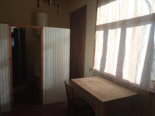 a room with a table and a window and a table and chairs at Two bedroom suite in Zugdidi