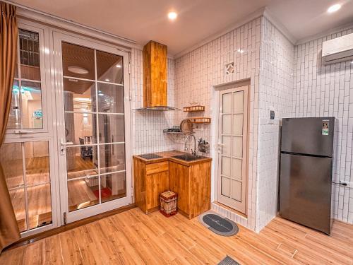 a kitchen with a refrigerator and a wooden floor at La Casa Di Dicembre in Hanoi