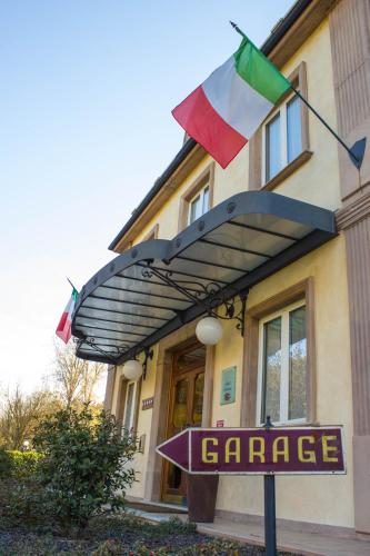 a sign in front of a building with flags at Hotel Valentino in Acqui Terme