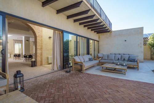 an outdoor patio with couches and a table at Alqueria de Vilches in Cullera