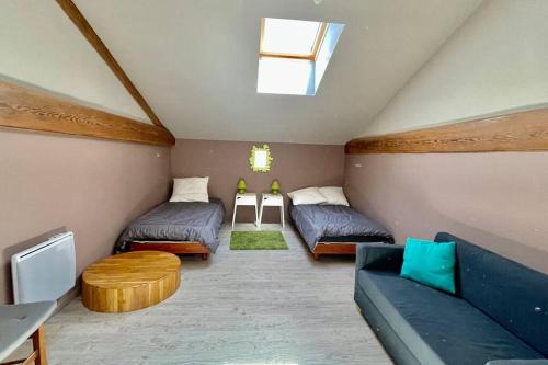 Cette chambre mansardée comprend deux lits et un canapé. dans l'établissement Le mantais, à Coulon
