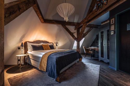 een slaapkamer met een bed in een kamer met balken bij Boutique Hotel Spedition a member of DESIGN HOTELS in Thun