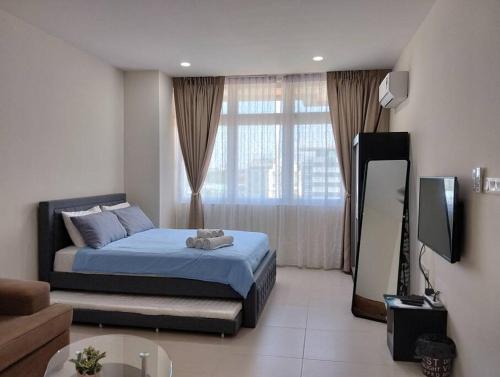 ein Schlafzimmer mit einem Bett und einem TV in einem Zimmer in der Unterkunft Business Getaways Suite 3 pa @ Riverine Kuching in Kuching