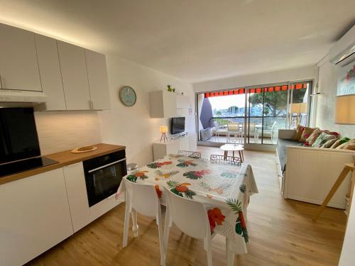 une cuisine et un salon avec une table et des chaises dans l'établissement Le nid douillet du Cabestan, au Grau-du-Roi