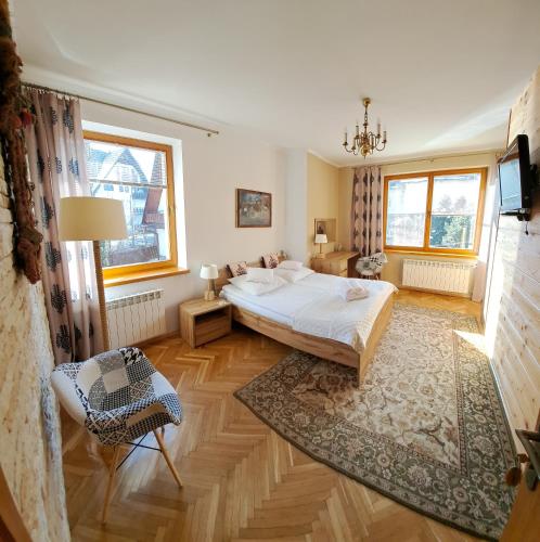 a bedroom with a bed and a chair in a room at Kalina in Zakopane