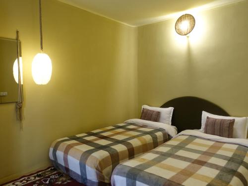 two beds in a room with green walls at The Melo pomelo courtyard. ( Right in between Thamel and basantapur durbar square) in Kathmandu