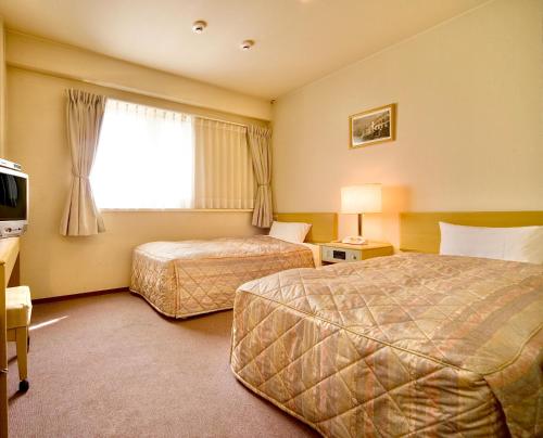 Postel nebo postele na pokoji v ubytování Kurashiki Ekimae Universal Hotel