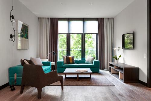 a living room with a blue couch and a table at DUPARC Contemporary Suites in Turin