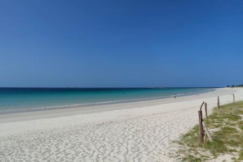 une plage avec l'océan en arrière-plan dans l'établissement Maison Penmarc'h 800 m plage, 10 mn La Torche, à Penmarcʼh