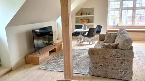 sala de estar con sofá, TV y mesa en Apartment in Danmark -Petersminde Exclusive Apartments, en Otterup