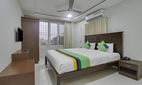 a bedroom with a large bed and a window at Rithikha Inn Crest in Chennai