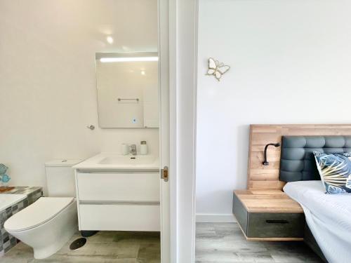 ein Bad mit einem Waschbecken, einem WC und einem Bett in der Unterkunft PaulMarie Apartment Gigantes Ocean Lounge in Puerto de Santiago