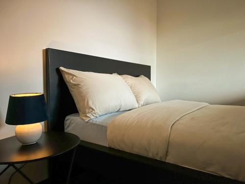 cama con cabecero negro y mesa con lámpara en Casper House, Near Maastricht, en Lanaken