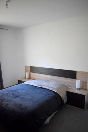 - une chambre avec un grand lit et 2 tables dans l'établissement Appartement climatisé T2 résidence, à Clermont-lʼHérault