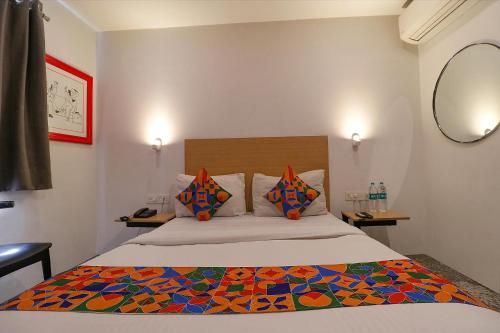 1 dormitorio con 1 cama con un edredón colorido en FabHotel La Serene Punjabi Bagh en Nueva Delhi
