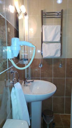 a bathroom with a sink and a toilet and towels at Butik Ertur Hotel in Doğubayazıt