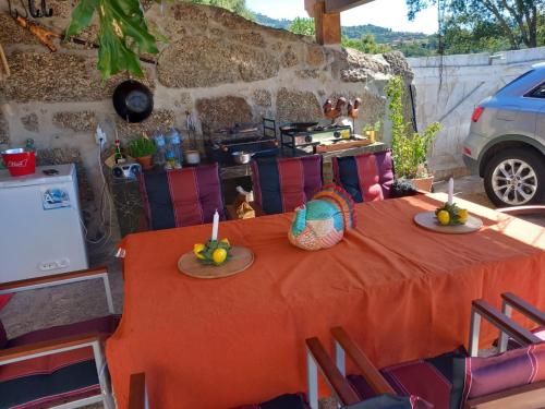 - une table orange avec deux plaques de fruits dans l'établissement A casa do Pastorinho, à Baião