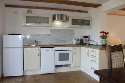 uma cozinha com electrodomésticos brancos e uma mesa de madeira em Ferienhaus Früh am See em Fürstenwerder