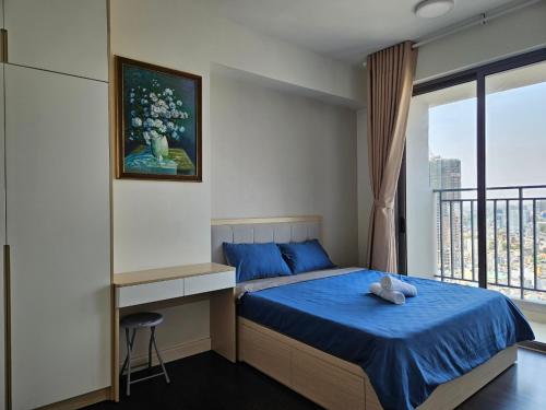 a bedroom with a blue bed and a window at Le May Home Rivergate Luxury Apartment Near Ben Thanh in Ho Chi Minh City