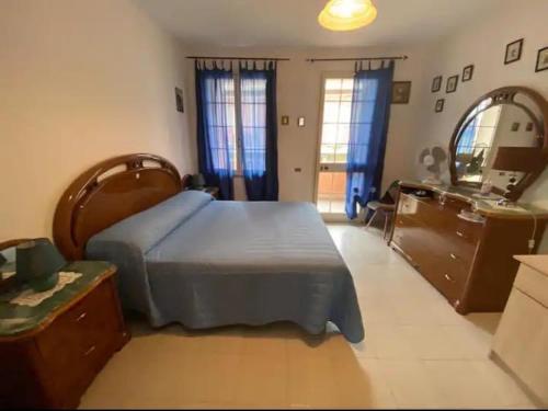 1 dormitorio con cama, tocador y espejo en Come a Casa!, en Oristano
