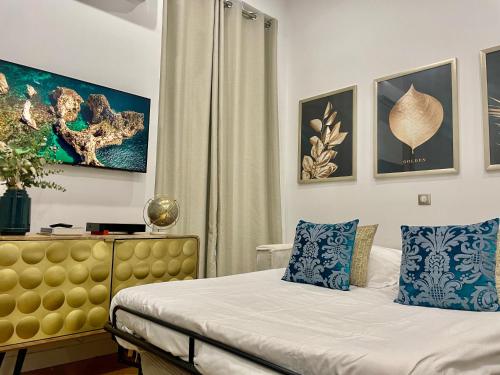 a bedroom with a bed with blue and white pillows at Ô portes du Palais in Avignon