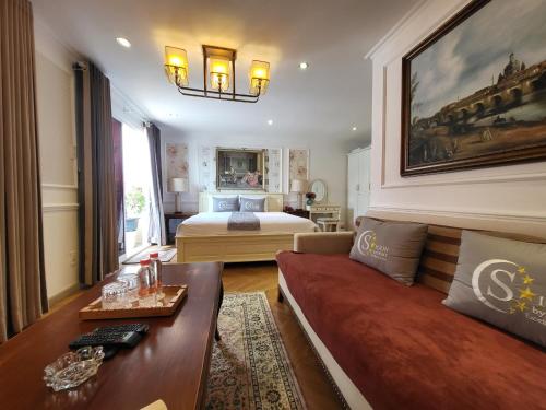 a living room with a bed and a couch at Saigon By Night Luxury Hotel in Ho Chi Minh City