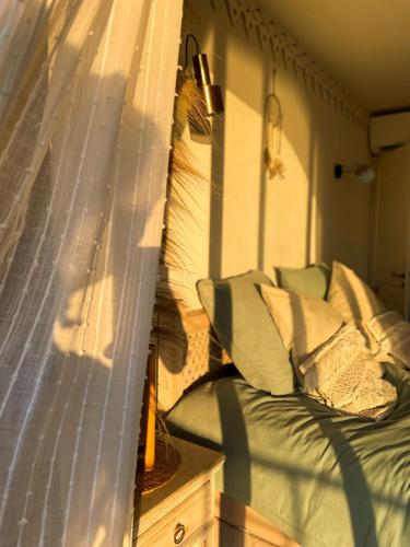 une chambre avec un lit et des oreillers sur un balcon dans l'établissement Mas Andalou Fabuleuse première ligne de mer, plage privative, à Frontignan