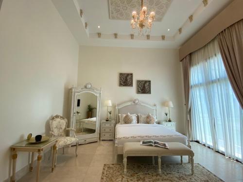 a white bedroom with a bed and a mirror at Western Hotel - Madinat Zayed in Madīnat Zāyid
