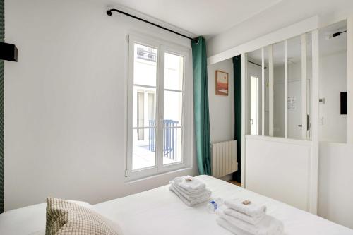 a white room with a bed and a window at Modern and functional apartment Ménilmontant in Paris